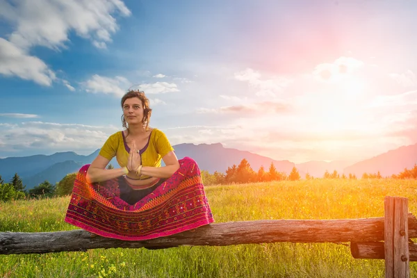 Spiritual practices of a girl sitting on fence — Stock Photo, Image