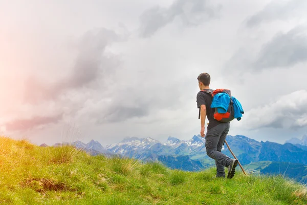 Niño caminando en las montañas con su palo en los prados — Foto de Stock