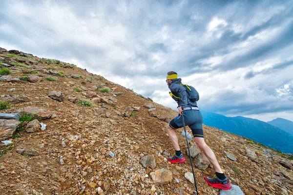 棒が付いている山でトレーニングしながら Skyrunner 選手 — ストック写真