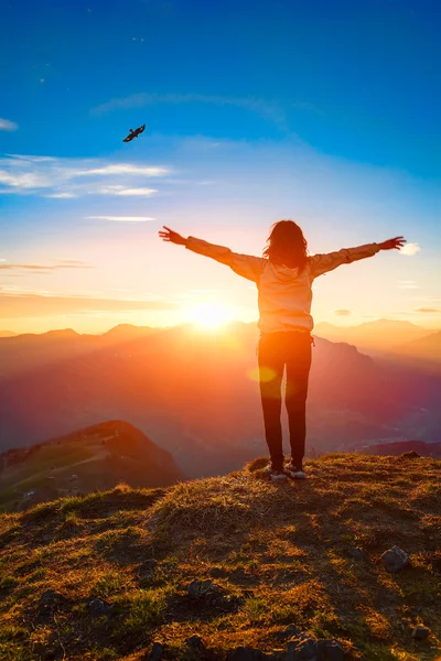 Mujer en la cima de una montaña al atardecer se ve águila — Foto de Stock