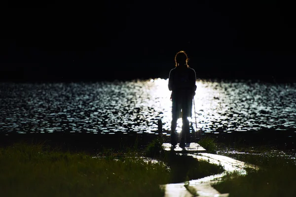 Young girl in hike in  silhouette on the small pier of a mountai — Stock Photo, Image