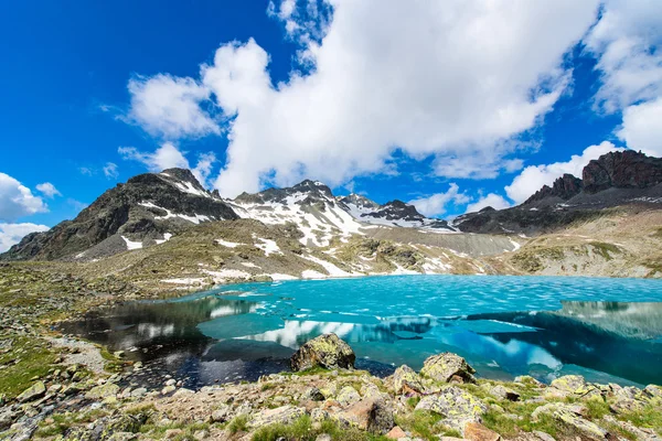 Small colored alpine lake with last ice — Stock Photo, Image
