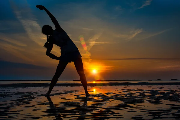 Kız yalnız Fitness pratikte bir gündoğumu sahilde — Stok fotoğraf