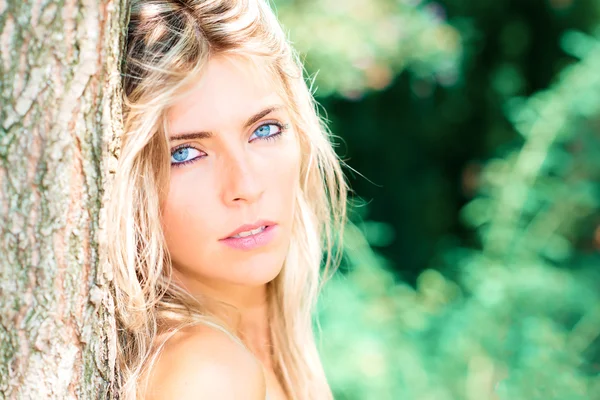 Retrato de una hermosa chica rubia con ojos azules en la naturaleza —  Fotos de Stock