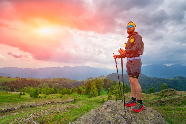 Ο άνθρωπος αναπαύεται στην κορυφή του βουνού κατά τη διάρκεια της πρακτικής του trail — Φωτογραφία Αρχείου