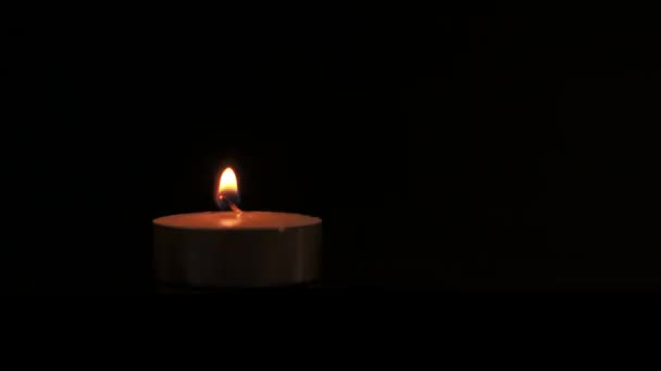 Eine Teelichterkerze Brennt Auf Schwarzem Hintergrund Close Video Pannin — Stockvideo