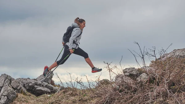 Sportowa Dziewczyna Skacze Między Kamieniami Podczas Alpejskiego Trekkingu — Zdjęcie stockowe