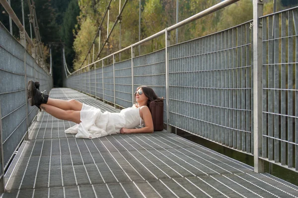 Une fille avec une valise repose sur le pont — Photo