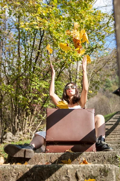 Mädchen spielt im Herbst mit Blättern — Stockfoto