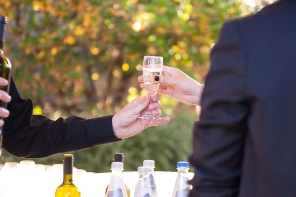 Detail van handen dienen een glas wijn — Stockfoto