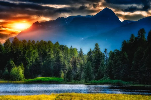 Lago de montanha com o sol nas nuvens — Fotografia de Stock