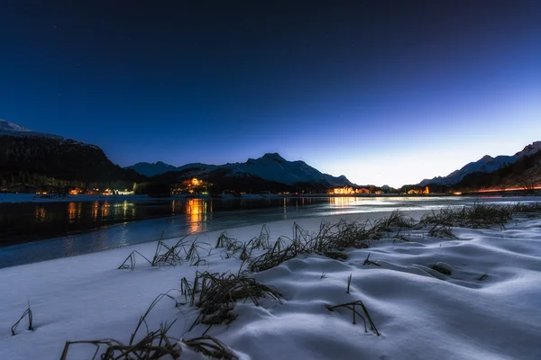 Lago alpino en la noche con pueblos en el fondo — Foto de Stock