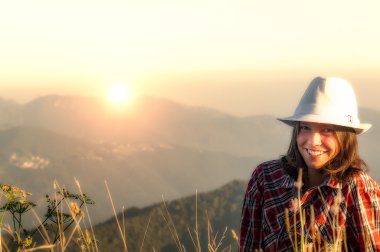 Smiling beautiful girl on the top of the mountain clipart