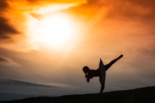 Ballerina-Silhouette, die allein in der Natur in den Bergen tanzt — Stockfoto