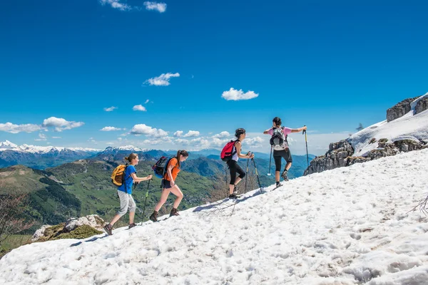 Grupp av tjejer går på snön i bergen, i glädje. — Stockfoto