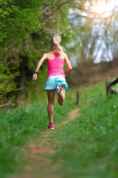 Chica rubia atleta corriendo en un sendero en el bosque — Foto de Stock