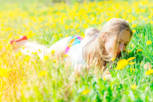 Sensual mujer acostada en el prado florido olfatea — Foto de Stock