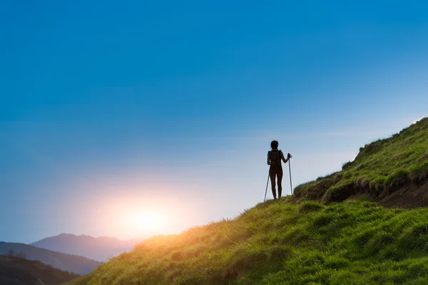 Silhouette de fille qui fait du trekking au coucher du soleil — Photo