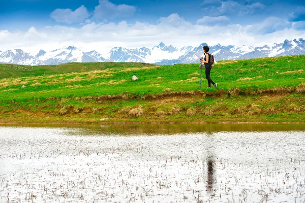 Kadın uzun yürüyüşe çıkan kimse yalnız göl dağ başına bir çayır — Stok fotoğraf