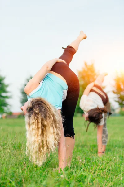 Yoga. zwei junge Frauen bei Yoga-Übungen im Freien — Stockfoto