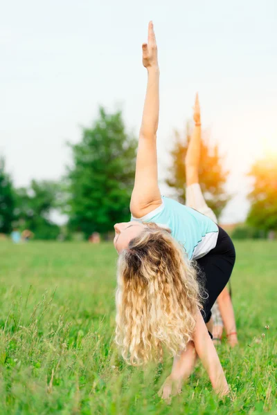 Yoga. zwei junge Frauen bei Yoga-Übungen im Freien — Stockfoto