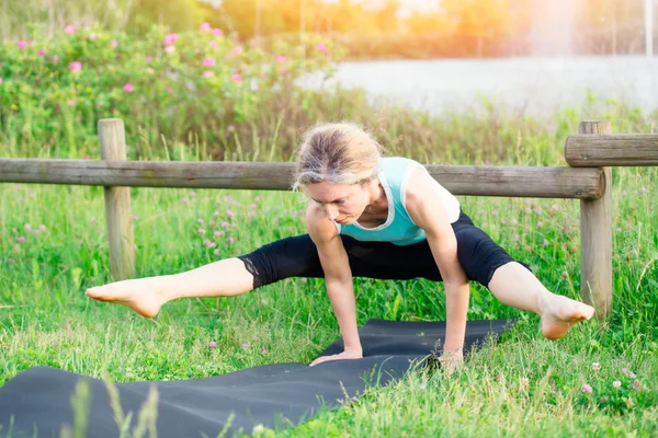 Yoga. Giovane donna che fa esercizio di yoga all'aperto — Foto Stock