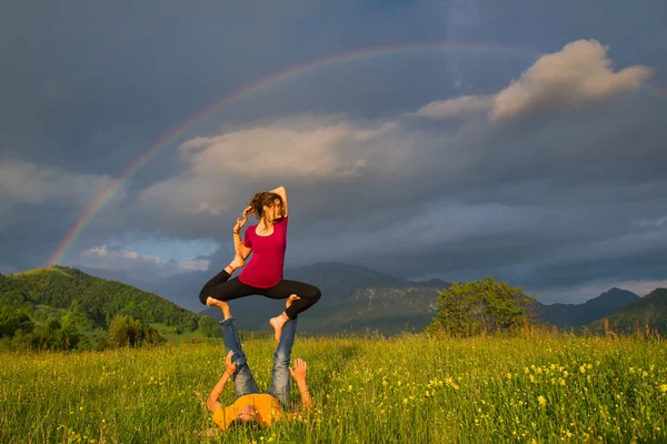 Positions Acroyoga girl of male in nature in the mountains with — Stock Photo, Image