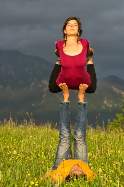 Pozice Acroyoga dívka samec v přírodě v horách — Stock fotografie