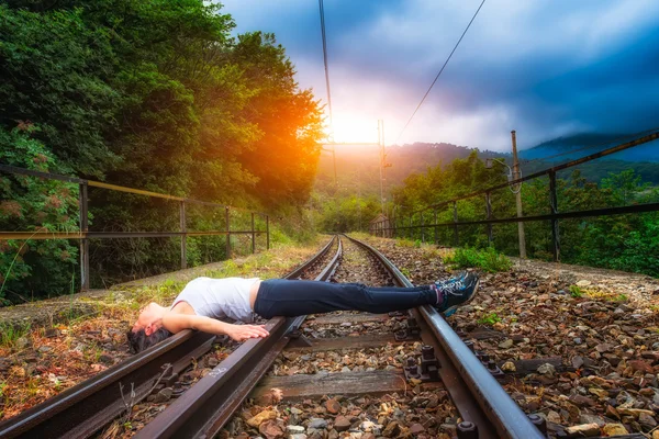 Chica acostada en las vías del tren —  Fotos de Stock