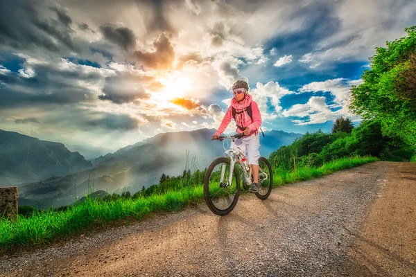 Chica bicicleta de montaña en un camino de montaña — Foto de Stock