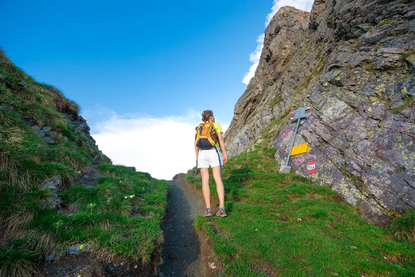 Meisje kijkt aanwijzingen hoogteweg in een bergpas — Stockfoto