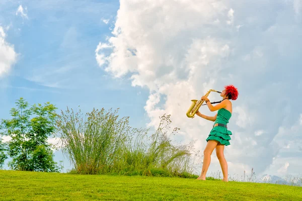 Young saxophonist (woman with the red hair) playing saxophone in — Stock Photo, Image