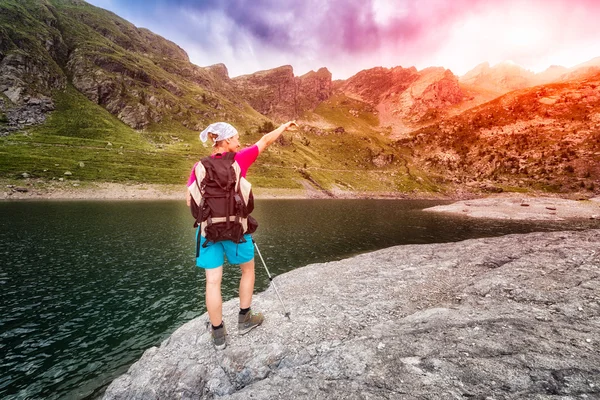 Caminhante feminina nas montanhas perto do lago — Fotografia de Stock