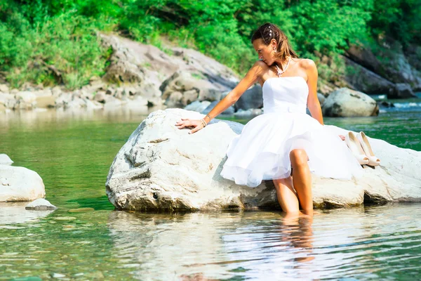 Lonely bride in a rock by the river — Stock Photo, Image