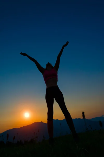 Silhouette einer Frau bei Sonnenuntergang in den Bergen — Stockfoto