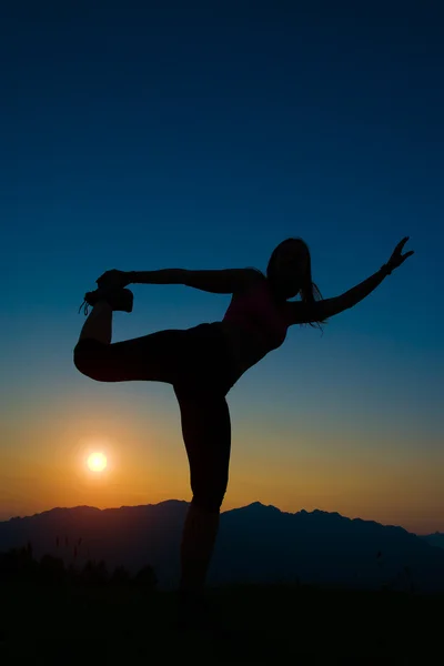 Silhouette einer Frau bei Sonnenuntergang in den Bergen — Stockfoto