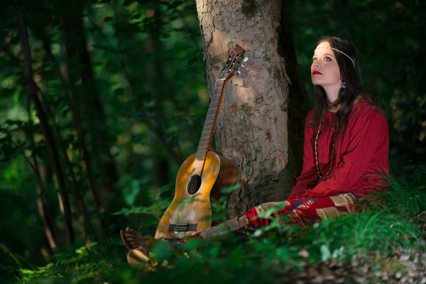 Hippie chica con la guitarra en el bosque — Foto de Stock