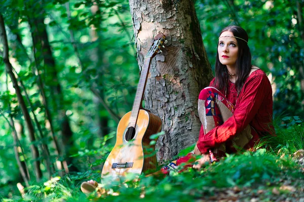 Hippie chica con la guitarra en el bosque — Foto de Stock