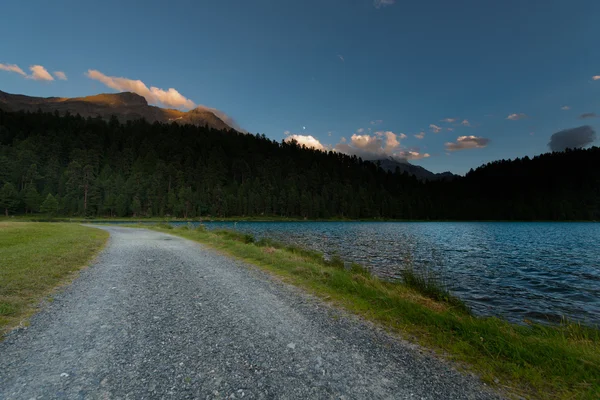 Dirt road near a mountain lake — Stock Photo, Image