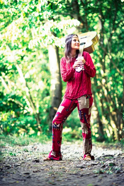 Hippie chica con la guitarra en el bosque — Foto de Stock