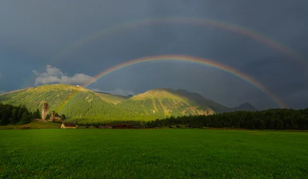 山の牧草地の実際の完全二重の虹 — ストック写真