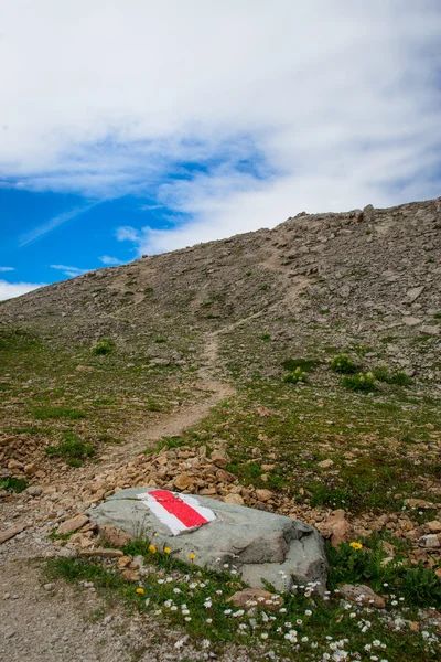 Marca roja en el camino de roca a montaña — Foto de Stock