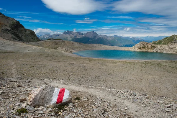 Semn roșu pe piatră spre un lac de munte — Fotografie, imagine de stoc