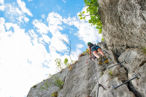 Young girl climbing a ladder into a climbing rock — Stock Photo, Image