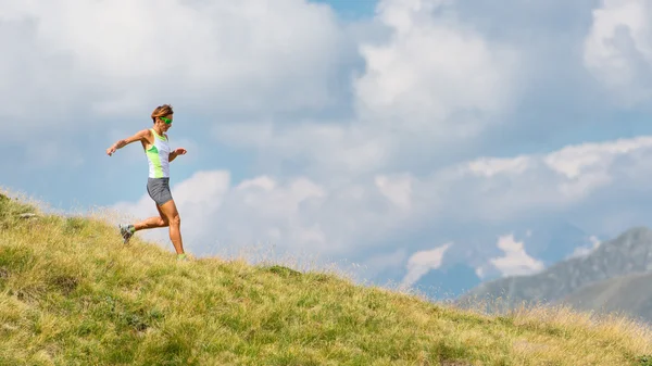 Una donna corre sulle montagne da sola — Foto Stock