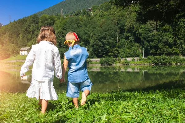 湖に歩いて手をつなぐ子どもたち — ストック写真