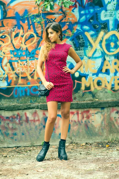 Vacker ung flicka framför en färgglad väggmålning — Stockfoto