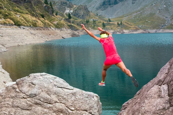 Girl athlete jumps between its stones in the mountains — Stock Photo, Image