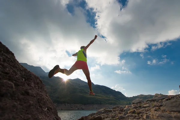 Saltando menina como ele corre nas montanhas — Fotografia de Stock