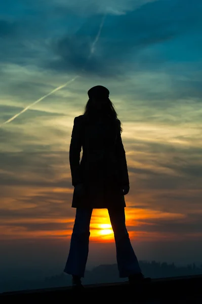 Девушка, стоящая с солнцем между ног — стоковое фото